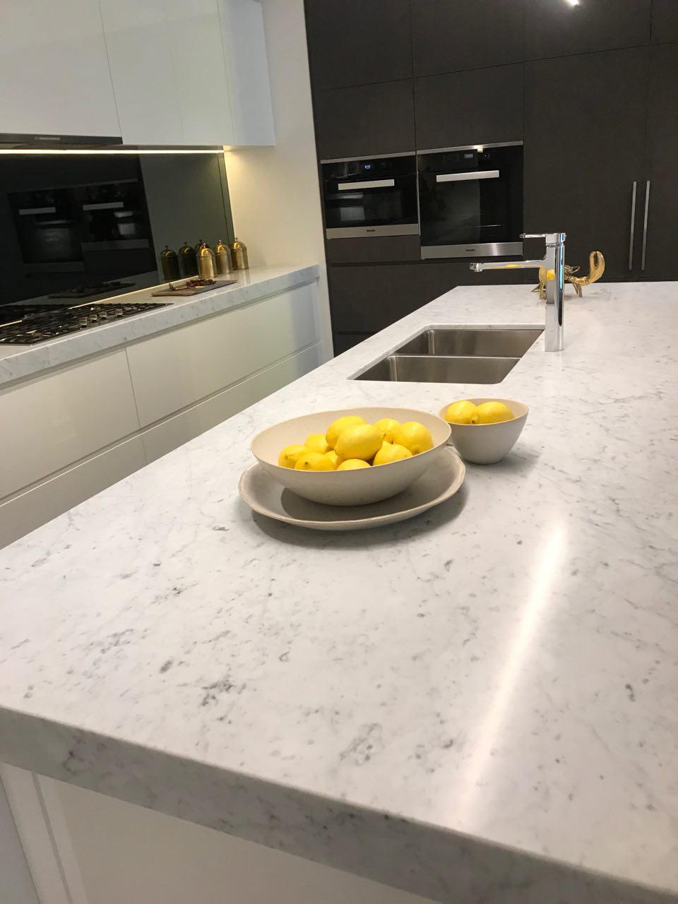 Bianco Carrara kitchen island with a double sink and bowls of lemons