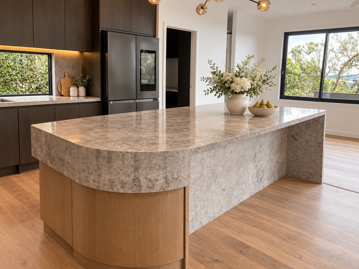 Curved island design with a Tundra Grey benchtop and waterfall panel.